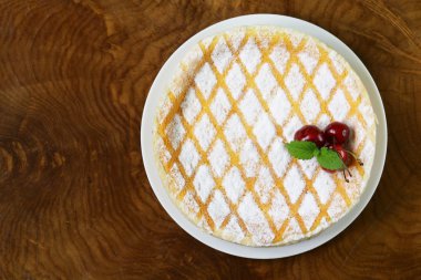 pudra şekeri ve beyaz tabakta kiraz ile ev yapımı cheesecake