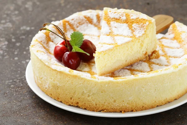 Torta di formaggio fatta in casa con zucchero a velo e ciliegia su un piatto bianco — Foto Stock