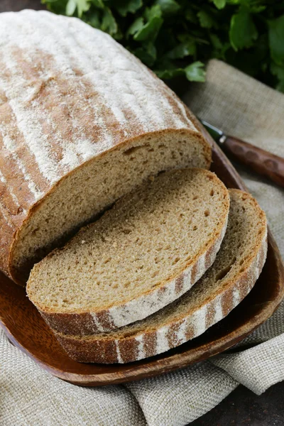 Домашняя буханка ржаного хлеба на деревянной тарелке — стоковое фото