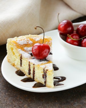 pudra şekeri ve beyaz tabakta kiraz ile ev yapımı cheesecake