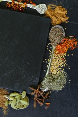Farklı baharat (kırmızı biber, zerdeçal, biber, anason, tarçın, safran siyah bir arka plan)