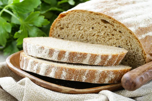 Homemade loaf of rye bread on a wooden plate — Stock Photo, Image