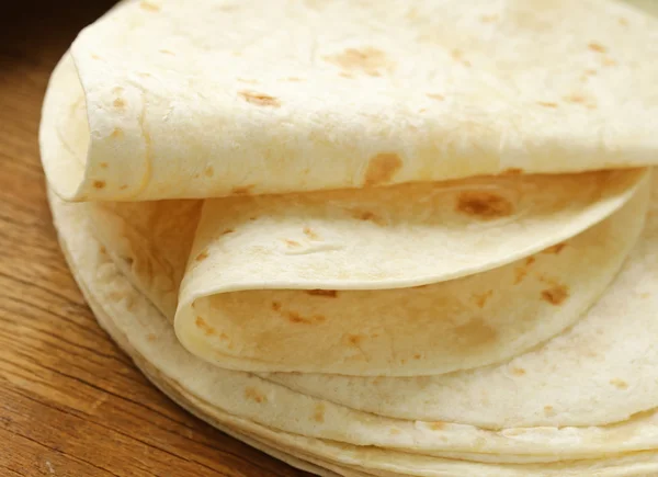 Pilha de tortilhas de farinha de trigo integral caseiras em uma mesa de madeira — Fotografia de Stock