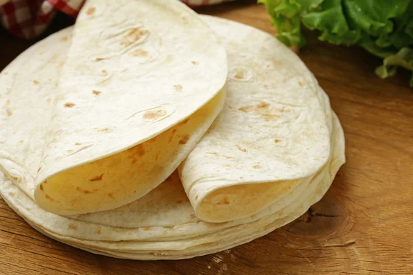 Verem a házi teljes kiőrlésű búzaliszt tortilla egy fából készült asztal — Stock Fotó