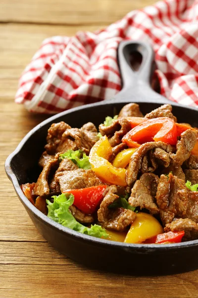 Sığır eti fajitas ahşap bir masa üzerinde tavada renkli biber ile — Stok fotoğraf