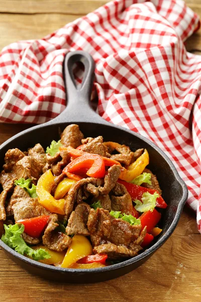 Rindfleisch-Fajitas mit bunten Paprika in der Pfanne auf einem Holztisch — Stockfoto