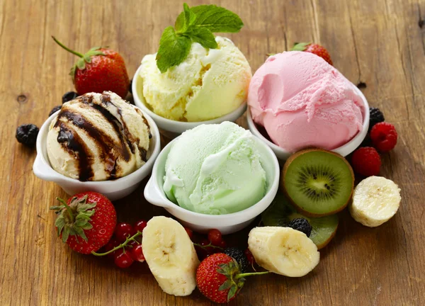 Assorted ice cream strawberry, banana, mint, chocolate and fresh berries on the wooden table — ストック写真