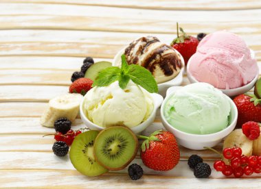 Assorted ice cream strawberry, banana, mint, chocolate and fresh berries on the wooden table