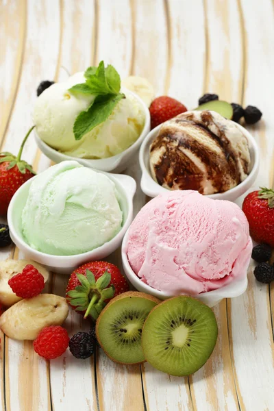 Assorted ice cream strawberry, banana, mint, chocolate and fresh berries on the wooden table — ストック写真