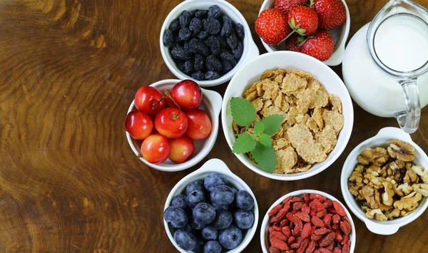 Conjunto de ingredientes para un desayuno saludable - muesli, fruta fresca y seca, frutos secos, bayas de goji — Foto de Stock