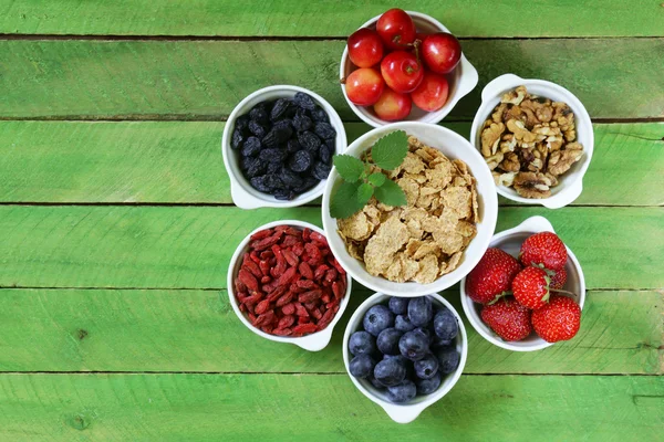 Zutaten für ein gesundes Frühstück - Müsli, frisches und getrocknetes Obst, Nüsse, Goji-Beeren — Stockfoto