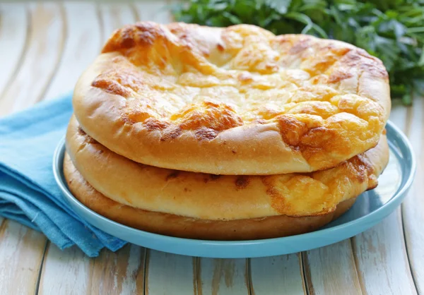 Pão chato assado com queijo em uma mesa de madeira — Fotografia de Stock