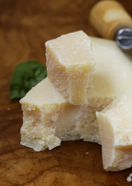 Pedaço de queijo parmesão natural em uma tábua de madeira — Fotografia de Stock