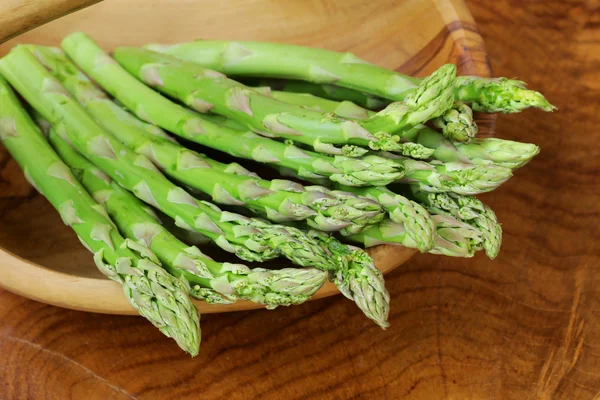 Natuurlijke organische groene asperges op een houten tafel — Stockfoto