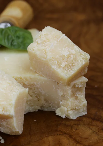 Кусок натурального сыра пармезан на деревянной доске — стоковое фото