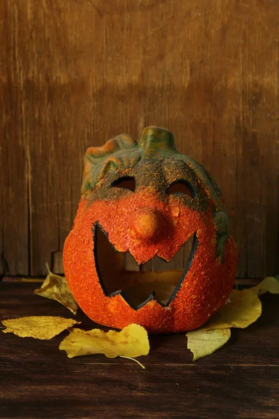 Halloween still life - pumpkin with yellow leaves on the wooden background — Stock Photo, Image