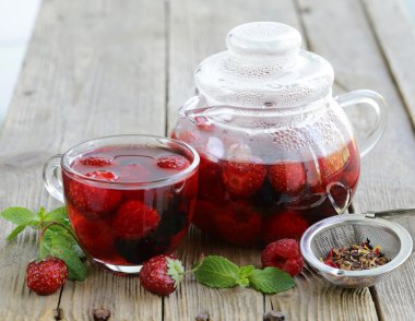 ahşap bir masa üzerinde kırmızı çay meyve berry