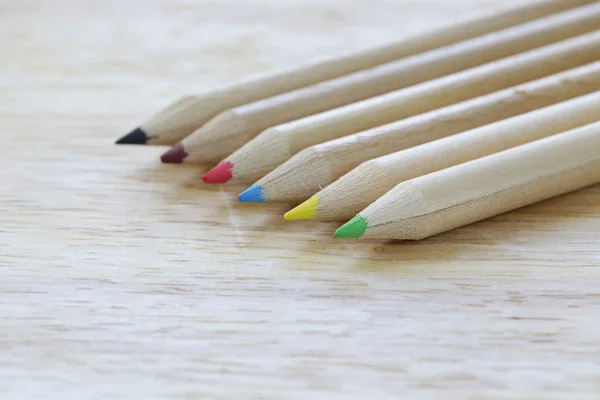 Lápices de madera de diferentes colores sobre un fondo de madera — Foto de Stock