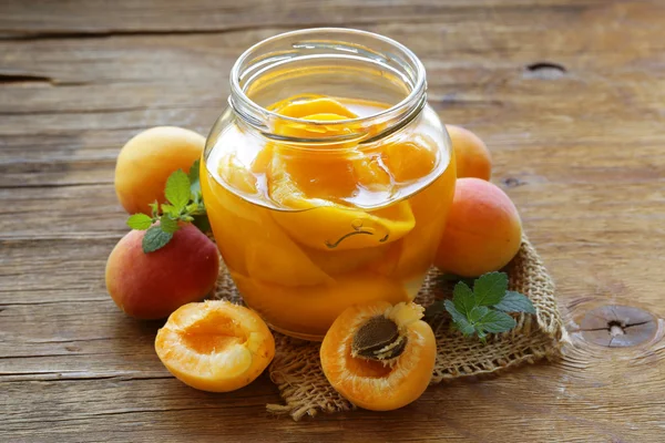 Консервированные персиковые фрукты в стеклянной банке — стоковое фото