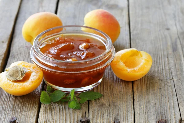 Confiture de pêche à l'abricot dans un bocal en verre sur fond de bois — Photo