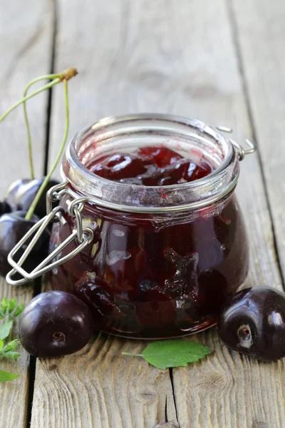 Marmellata di ciliegie biologiche fatte in casa su un tavolo di legno — Foto Stock