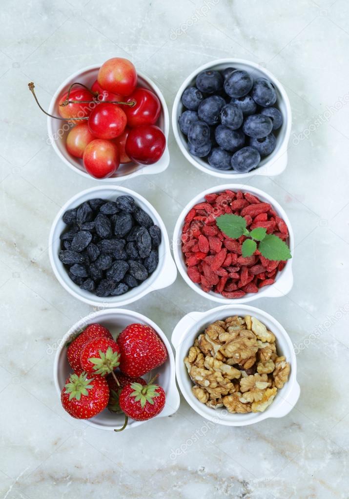 set of ingredients for a healthy food breakfast - muesli, fresh and dried fruit, nuts, goji berries