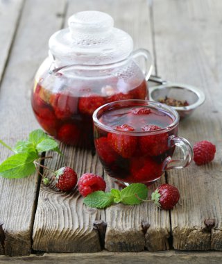 ahşap bir masa üzerinde kırmızı çay meyve berry