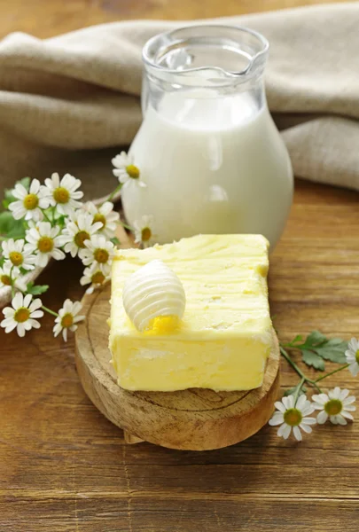 Frische gelbe Butter mit einem Krug Milch, rustikales Stillleben — Stockfoto