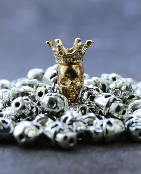 Guld unik skallen bland vanliga metall dödskallar — Stockfoto