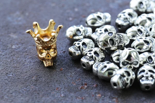 Zlata jedinečné lebka mezi obyčejné kovové lebky — Stock fotografie