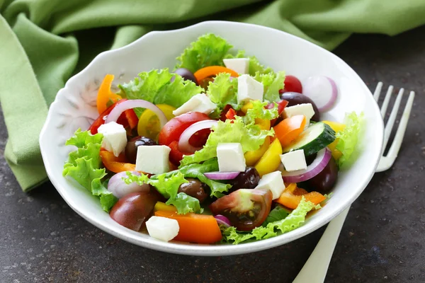 Traditionele Griekse salade met feta kaas, tomaten, olijven en groene sla — Stockfoto