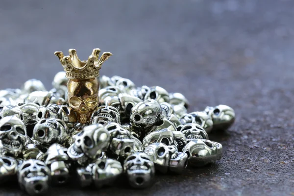 Guld unik skallen bland vanliga metall dödskallar — Stockfoto