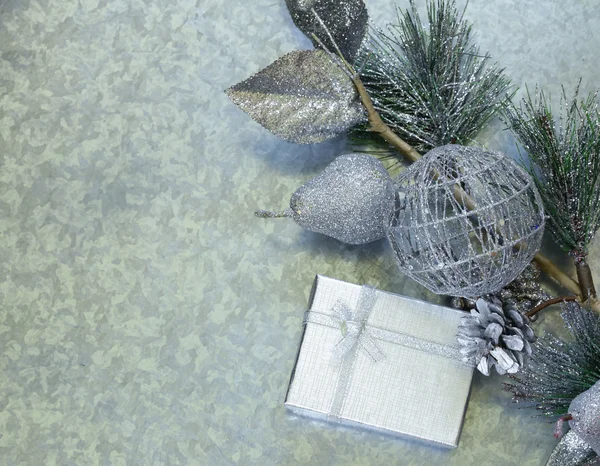 Ramas de abeto de fondo de Navidad con decoraciones de plata y caja de regalo — Foto de Stock