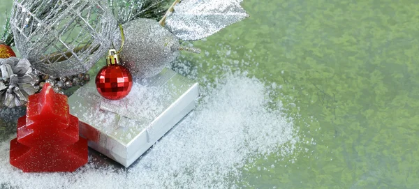 Weihnachten Hintergrund Tannenzweige mit silbernen Dekorationen und Geschenkbox — Stockfoto