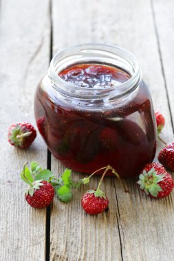 ahşap bir masa, rustik tarzı üzerinde cam kavanozda çilek reçeli