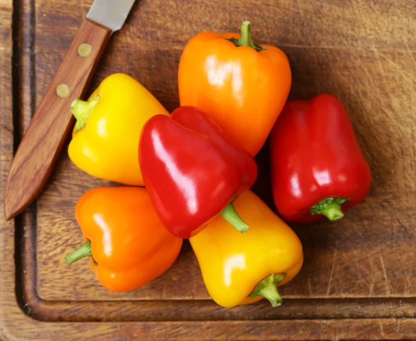 Fresh organic bell peppers on a wooden board — Stock Photo, Image