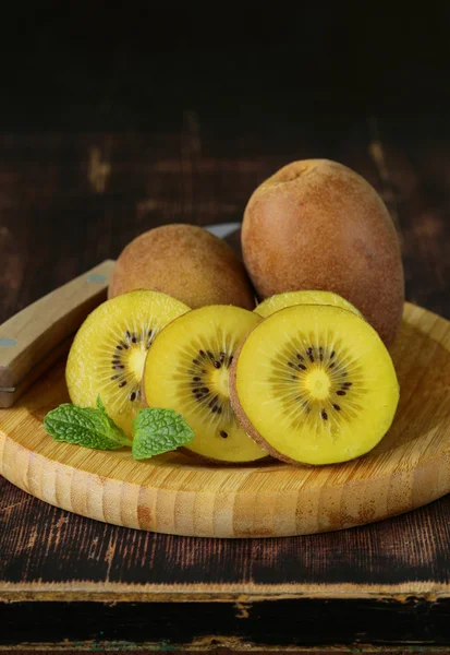 Organic kiwi fruit on wooden plate — Stock Photo, Image