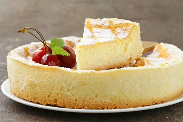 Torta di formaggio fatta in casa con zucchero a velo e ciliegia su un piatto bianco — Foto Stock