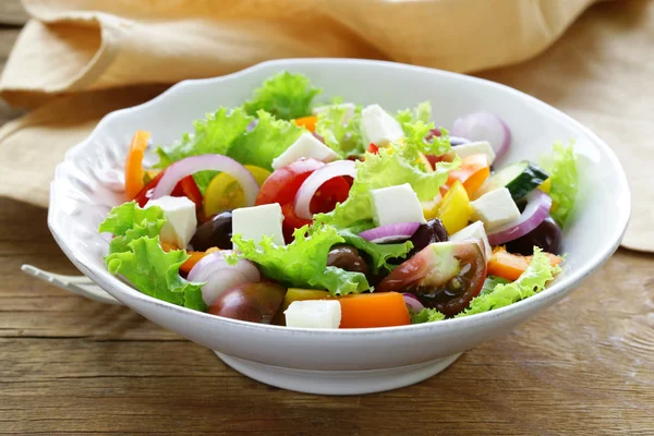 Traditional Greek salad with feta cheese, tomatoes, olives and green lettuce — Stock Photo, Image