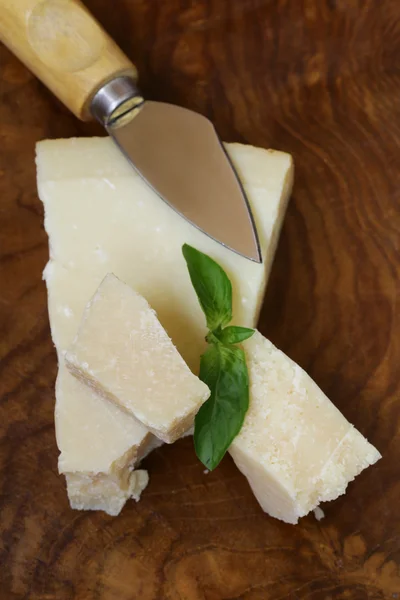 Stuk van natuurlijke Parmezaanse kaas op een houten bord — Stockfoto