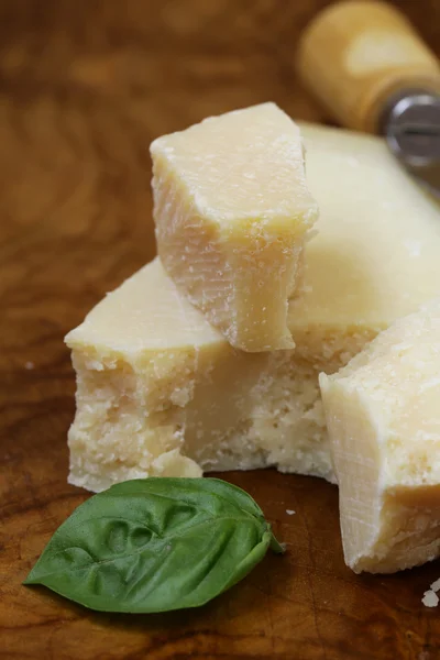 Kus přírodní sýr parmezán na dřevěném prkénku — Stock fotografie