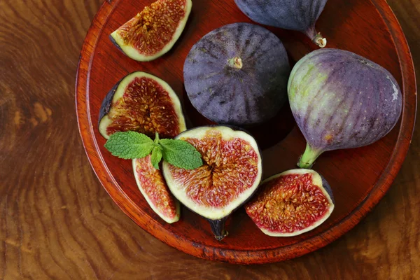 Fresh organic purple fig fruit on wooden plate — Stock Photo, Image