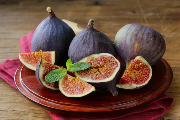 Fruta de higo púrpura orgánica fresca en placa de madera — Foto de Stock