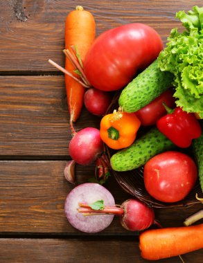 ahşap arka plan üzerinde bir salata (salatalık, domates, marul, turp, havuç) için çeşitli sebze