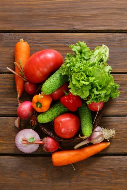 ahşap arka plan üzerinde bir salata (salatalık, domates, marul, turp, havuç) için çeşitli sebze