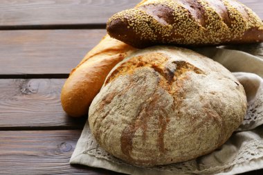 ev yapımı taze ekmek (çavdar, susam, beyaz) ahşap arka plan üzerinde