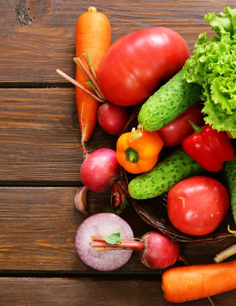 Las hortalizas distintas para la ensalada (los pepinos, los tomates, la lechuga, los rábanos, la zanahoria) sobre el fondo de madera —  Fotos de Stock