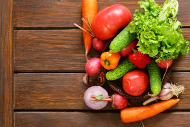 ahşap arka plan üzerinde bir salata (salatalık, domates, marul, turp, havuç) için çeşitli sebze