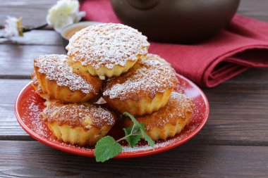 kırmızı bir tepside pudra şekeri ile Mini madeleine muffins