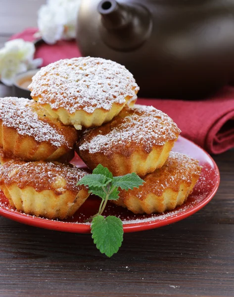 Mini muffin madeleine con zucchero a velo su un piatto rosso — Foto Stock